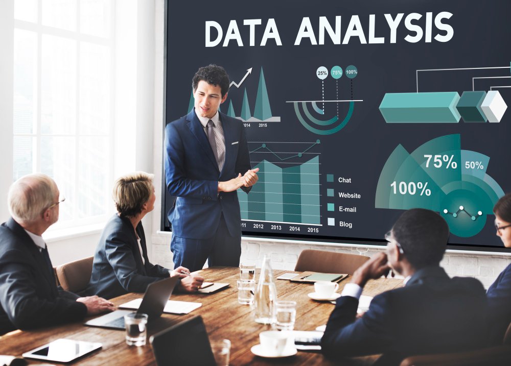 a man standing in front of a large screen showing data analysis